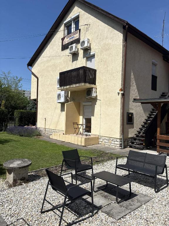 a group of chairs sitting in front of a building at Kincső Vendégház Siófok in Siófok
