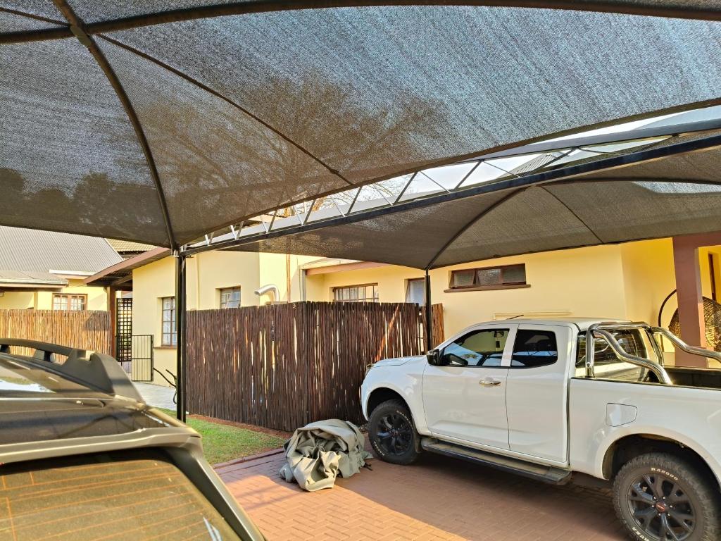 a white truck parked under a canopy in a driveway at The Museum in Sabie