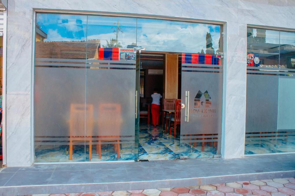 a large glass window of a restaurant with a person in it at Moveck Inn in Dar es Salaam