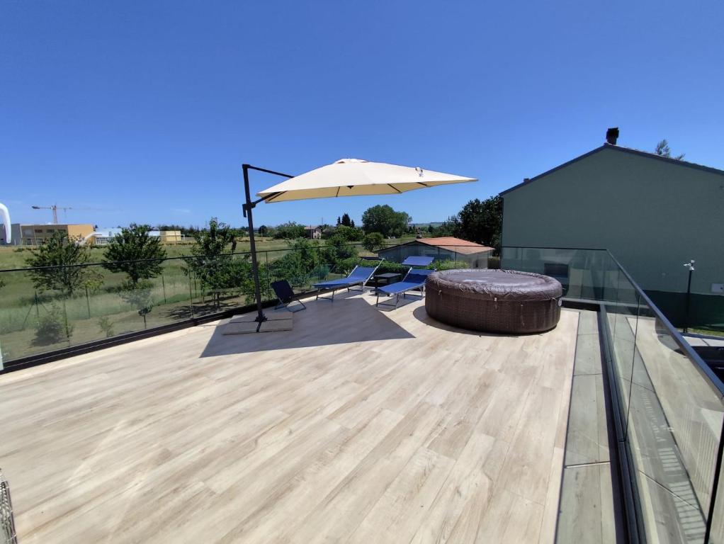 a patio with an umbrella and a chair and a bench at Appartamenti Cataleya in Cuccurano