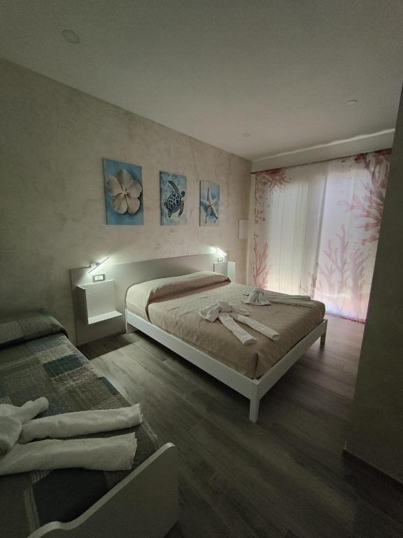 a bedroom with two beds and a window at Blue Cave b&b in Palinuro