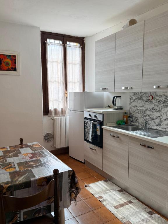 a kitchen with a table and a stove top oven at casa rosa in Lodi