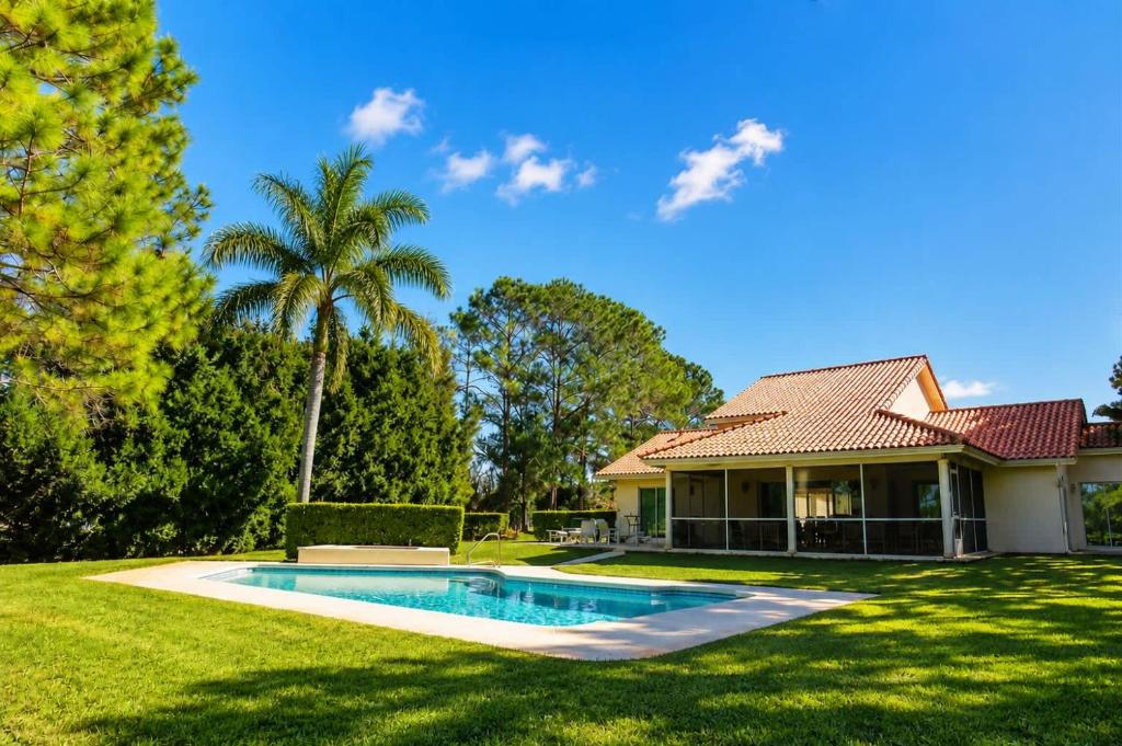 a house with a swimming pool in the yard at SWISS 24 - Lake Stephanie in Clermont