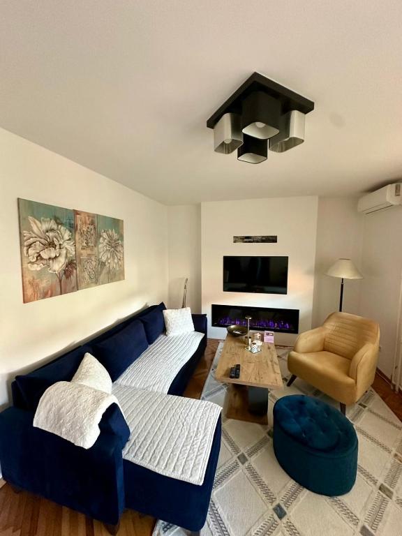 a living room with a blue couch and a table at Golden Apartment in Travnik