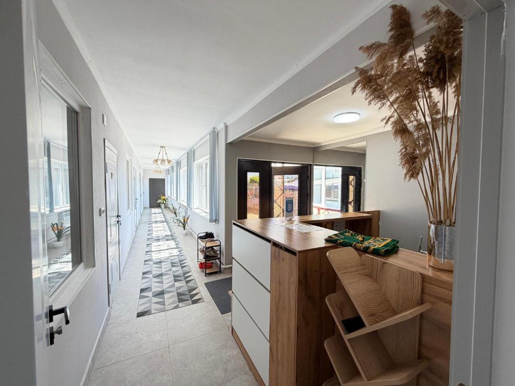 a kitchen with a counter and a long hallway at Like House Karakol in Karakol