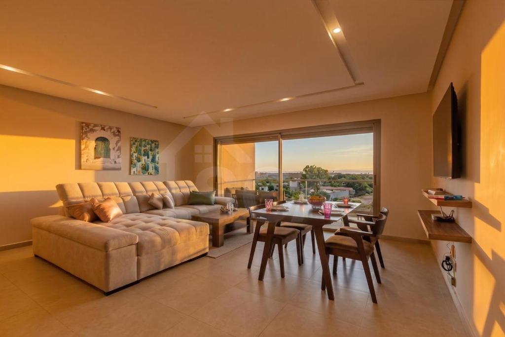 a living room with a couch and a table at Ocean & Sunset View Pool & Parking in Tamraght Ouzdar