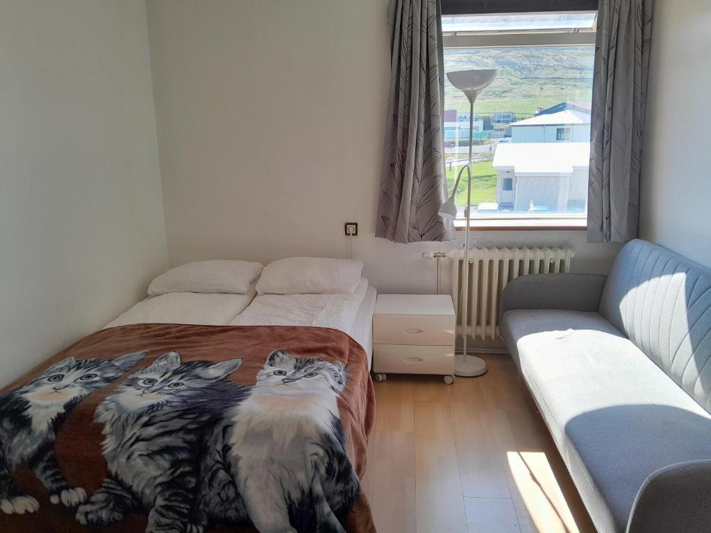 a bedroom with a bed and a couch at Guesthouse in Ólafsvík