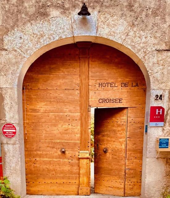 a wooden door in a building with a sign on it at Hotel De La Croisée in Poncin