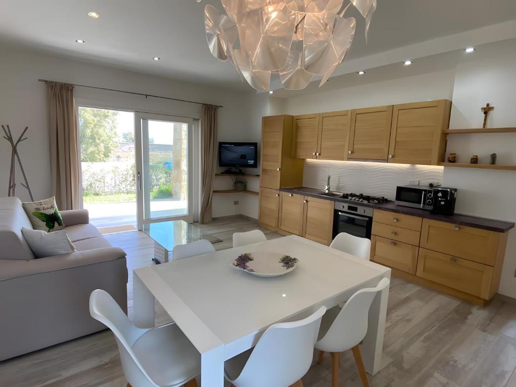 a kitchen and living room with a white table and chairs at R House II - Puntocasabudoni in Budoni