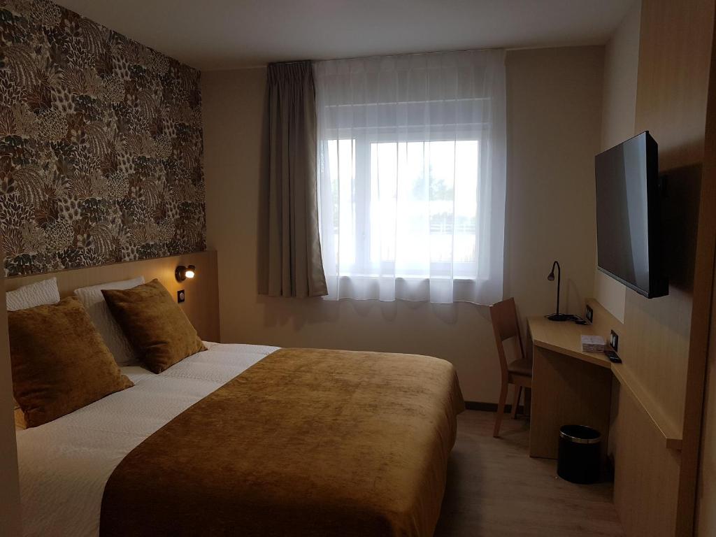 a hotel room with a bed and a television at The Originals City Hôtel-Restaurant-Terrasse du PAarc Gravelines Dunkerque in Gravelines