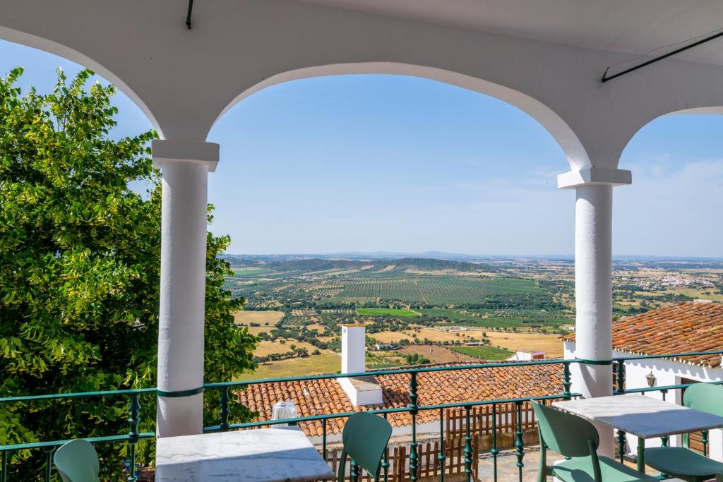 a balcony with a table and chairs and a view at Dom Nuno by Horta da Moura in Monsaraz