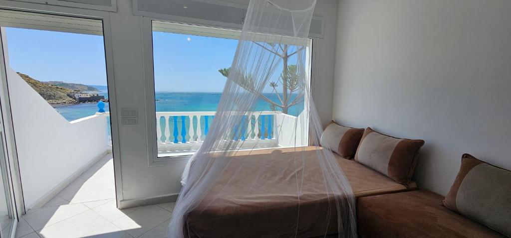 a bedroom with a bed and a large window at Rychance Playa Blanca Tanger in Tangier