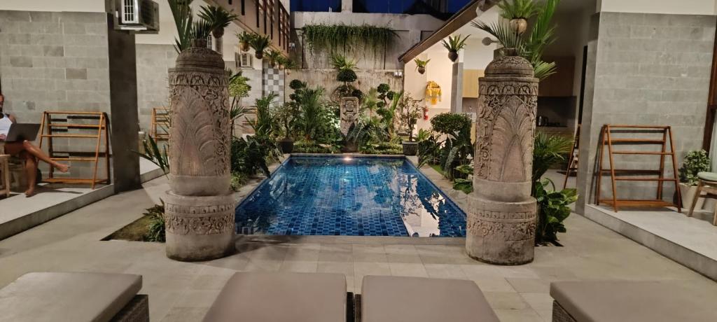 a swimming pool in a building with two columns at Kubunaku Sanur Bali in Sanur