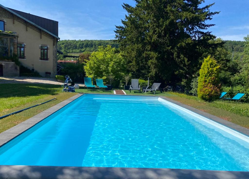a large blue swimming pool in front of a house at La Fraizière in Arnaville