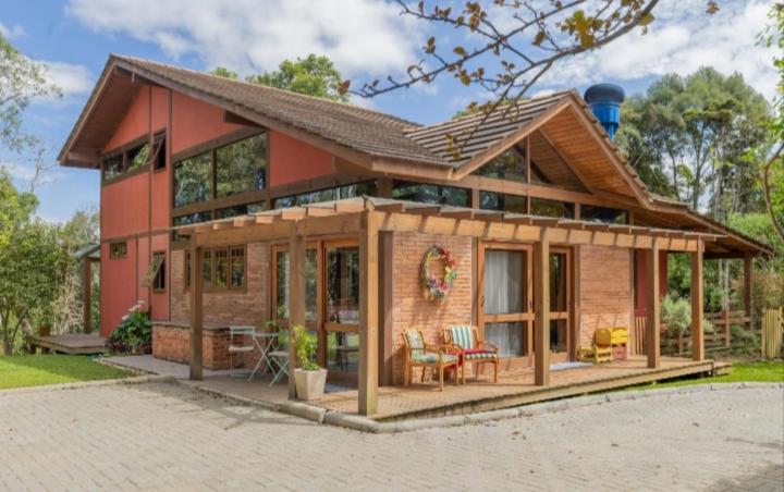 a large wooden house with a lot of windows at Casa Bosque Encantador in Rancho Queimado
