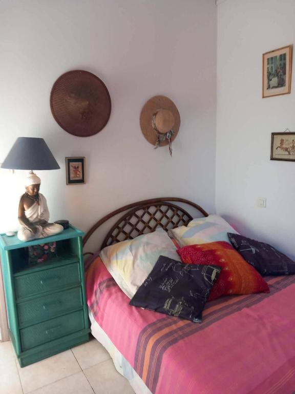 a bedroom with a bed and a lamp on a night stand at Villa Cardicciosa in Ghisonaccia