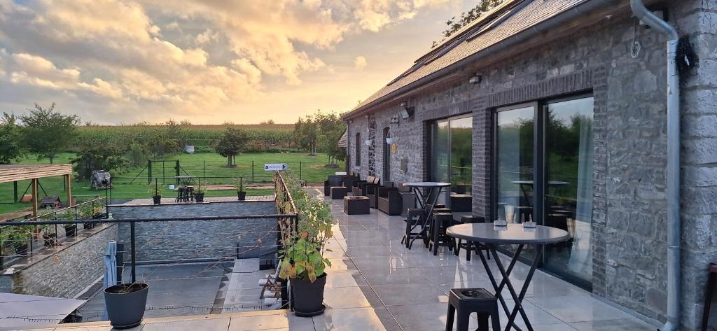 a patio with tables and chairs on a building at Durbuy House in Durbuy