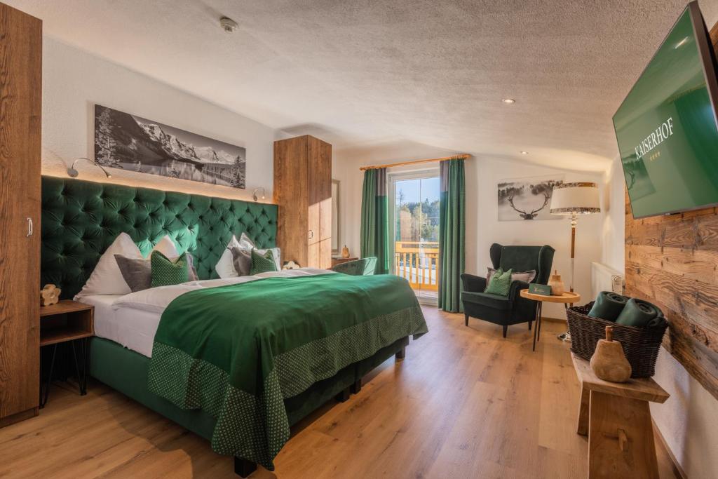a hotel room with a green bed and a balcony at Vitalhotel Kaiserhof in Seefeld in Tirol
