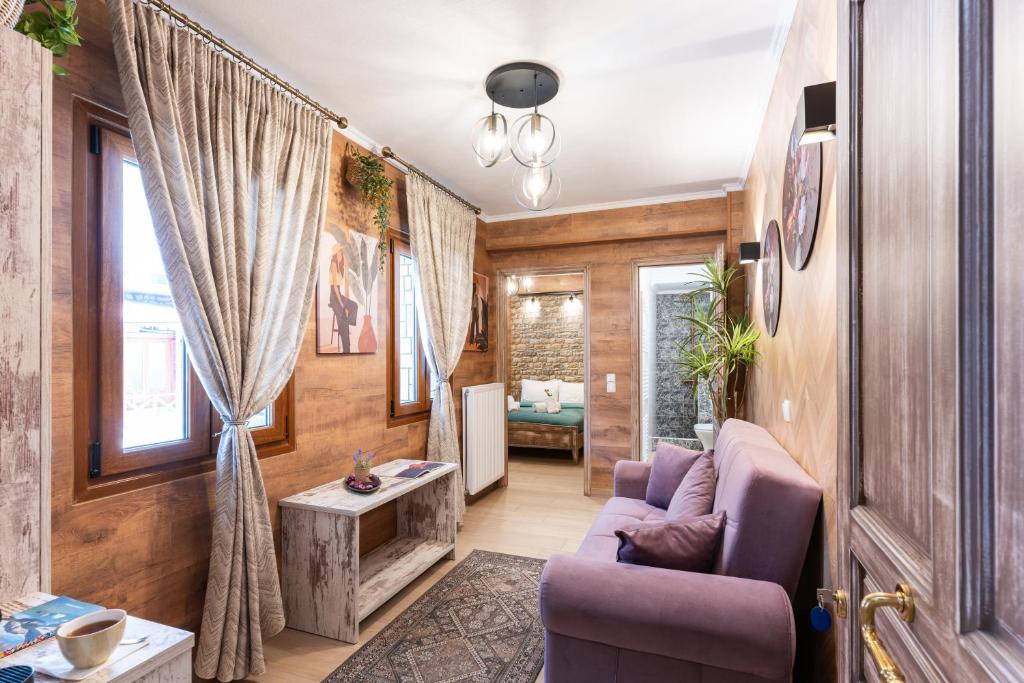 a living room with a purple couch and a table at Lume in Metsovo