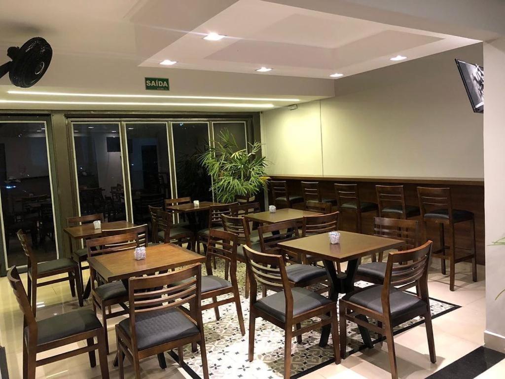 a dining room with wooden tables and chairs at CMS PLAZA Hotel in Serrana