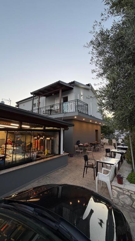 a house with a balcony and a table and chairs at Dhoma Elena in Dhërmi