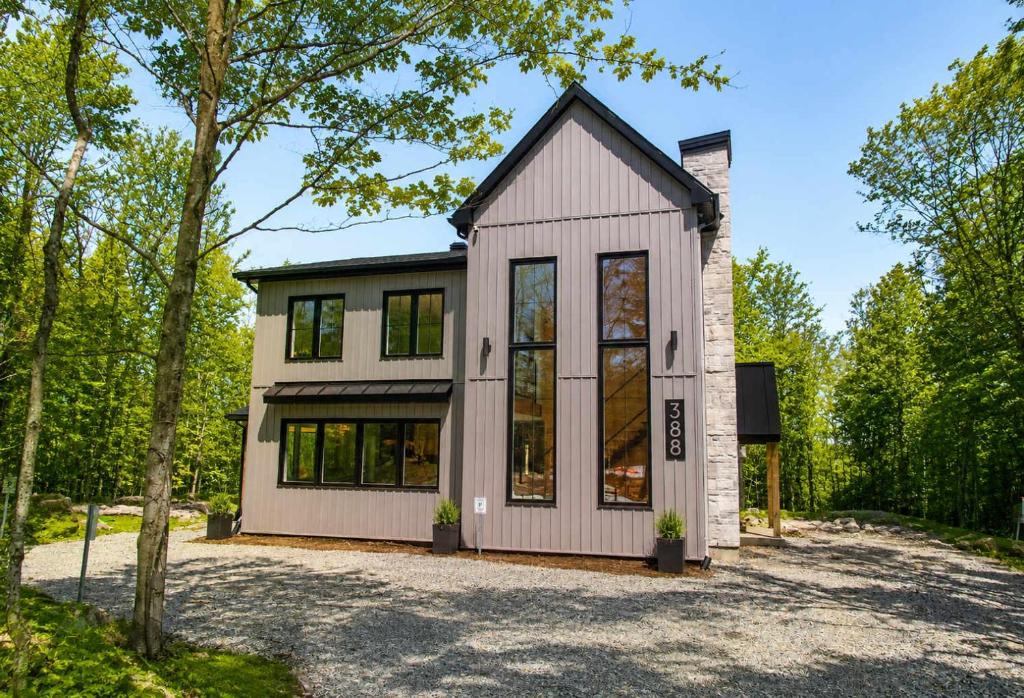 a small white house with a lot of windows at Spa & Lake - Orphee in Chertsey