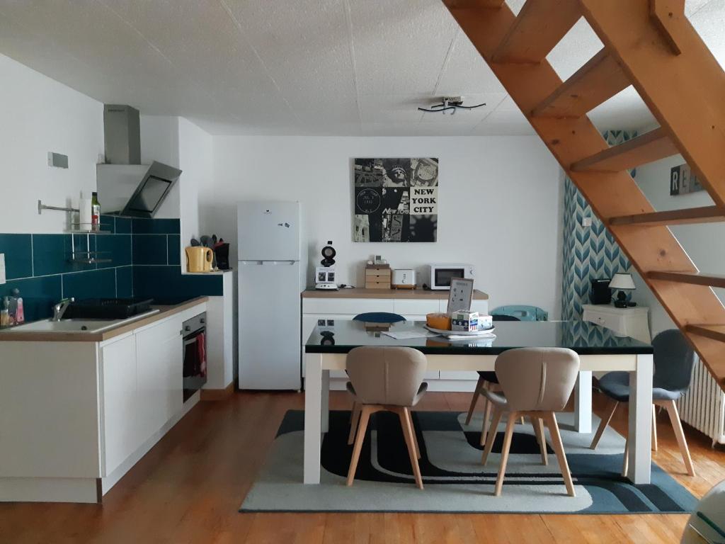 a kitchen with a table and chairs in a room at L'escapade Guingampaise in Guingamp