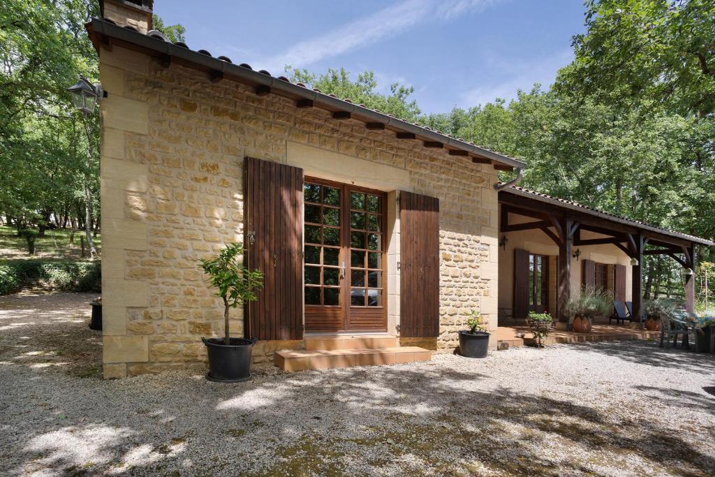 a small brick house with a large glass door at Gite Chante' Alouette – Le Bugue in Le Bugue