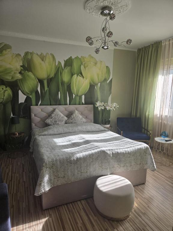 a bedroom with a bed with a flower mural on the wall at Kate Sea Apartment in Pärnu
