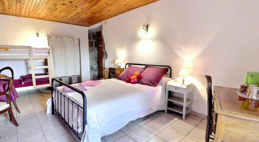 a bedroom with a bed and a table and a bed at Chambre d'hôtes L'Adrienne in Chazeaux