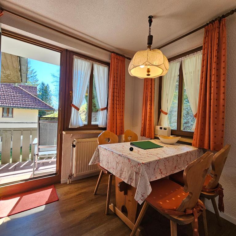 a dining room with a table and some windows at FeWo Schwarzwaldglück Todtmoos mit Sauna, Tischtennis, Fitness, Stellplätzen in Todtmoos