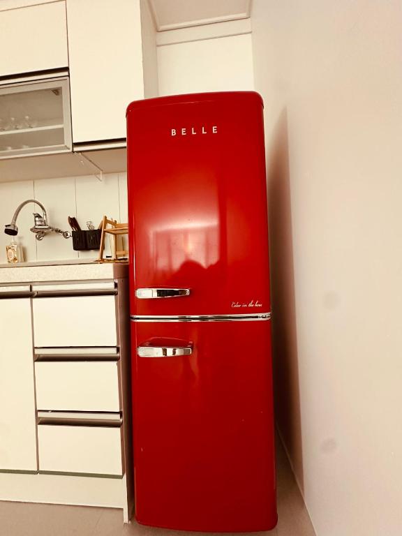 a red refrigerator in the corner of a kitchen at 라곰빌리지 in Paegun-dong
