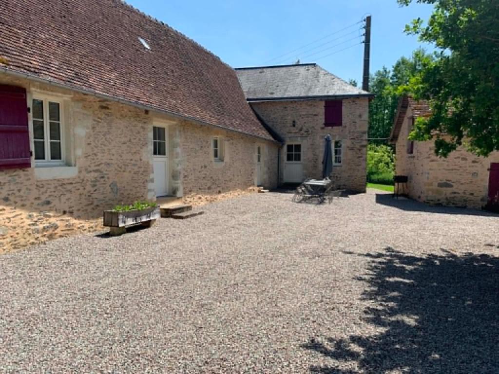 a large gravel yard in front of two buildings at Gite de Foulleray n 14 in Rouez