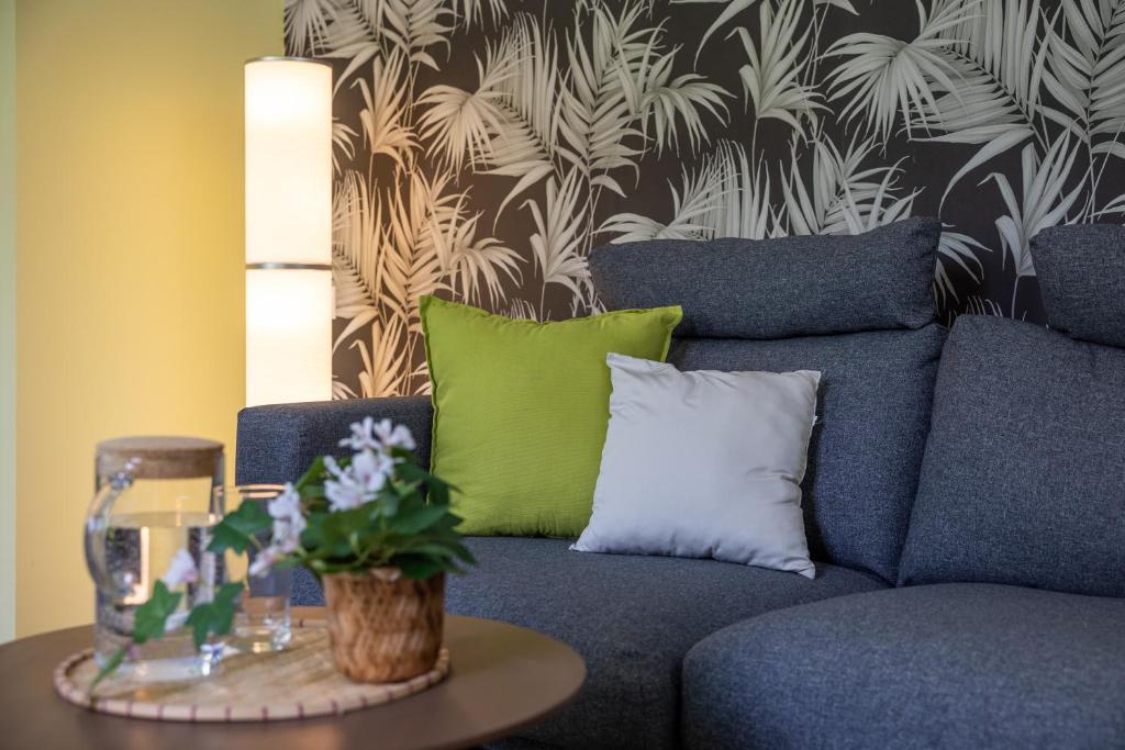 a blue couch with green pillows and a table at Szent Margit Apartman in Veszprém