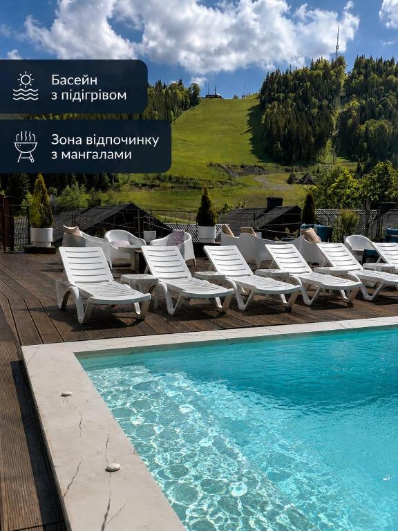 a group of lounge chairs next to a swimming pool at Krucha in Bukovel
