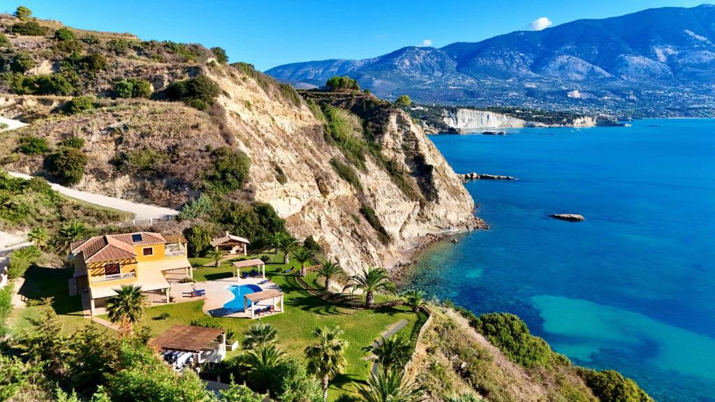 a house on a cliff next to the ocean at Villa Alexandros in Spartià