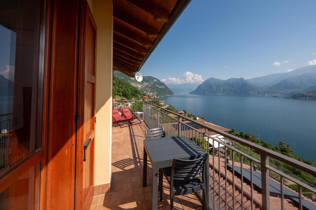 a balcony with a table and chairs overlooking a lake at Lake Iseo Panorama Suite in Tavernola Bergamasca