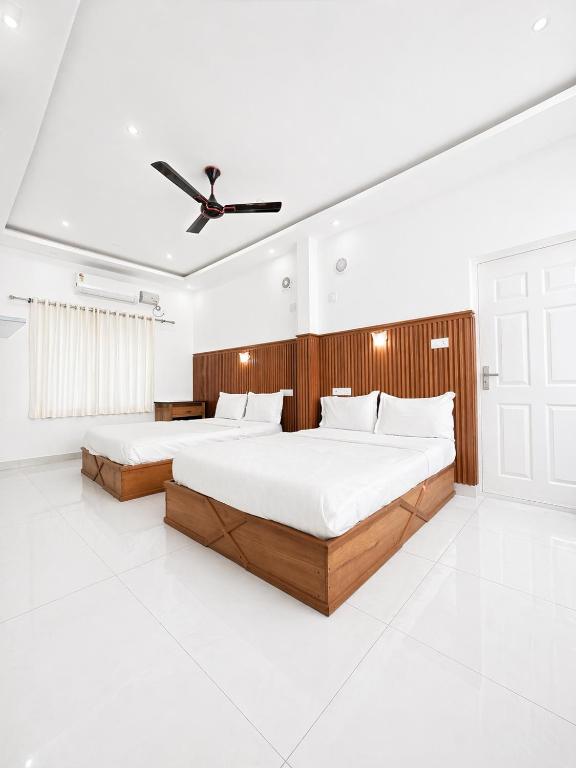 a bedroom with two beds and a ceiling fan at Real Casa in Anachal