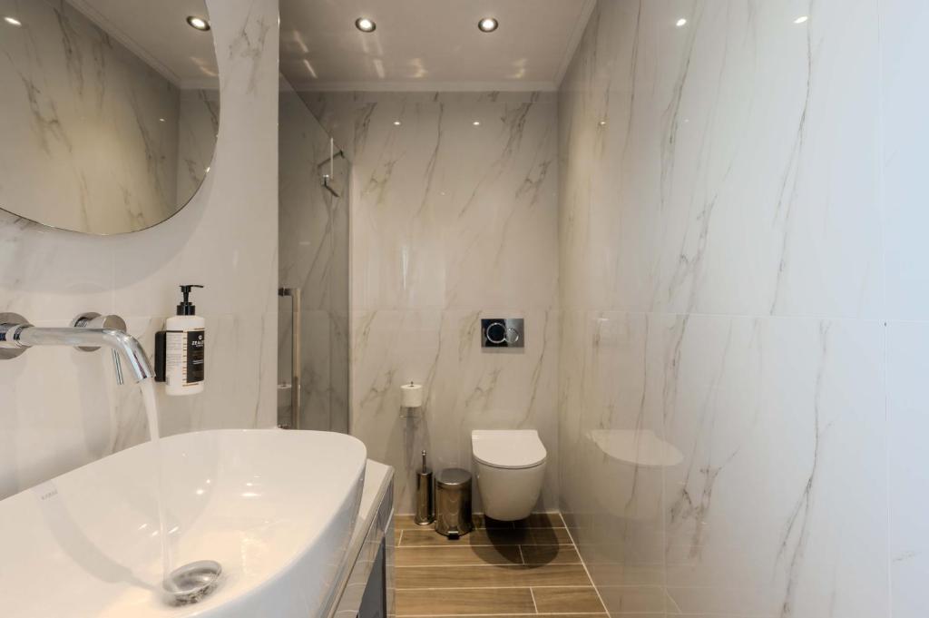 a white bathroom with a sink and a toilet at Orizon Apartments in Limenas