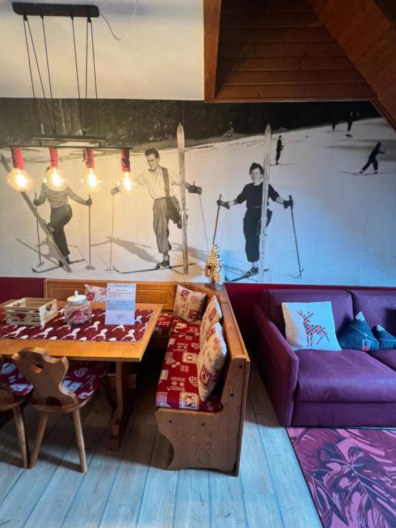 a living room with a purple couch and a table at Mandi Mandi a Tarvisio in Tarvisio