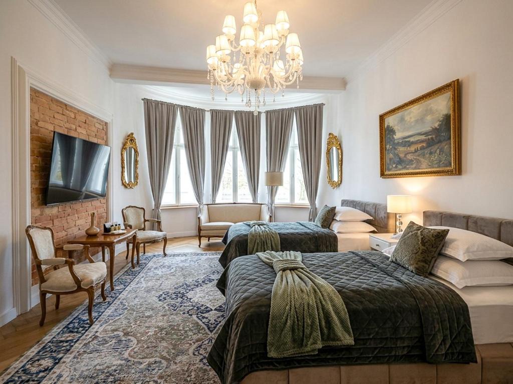 a bedroom with two beds and a chandelier at Belle Époque Sopot in Sopot