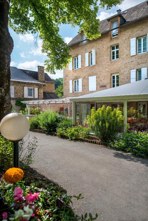 a building with a bunch of flowers in front of it at Village Vacances L'Oustal in Salles-la-Source