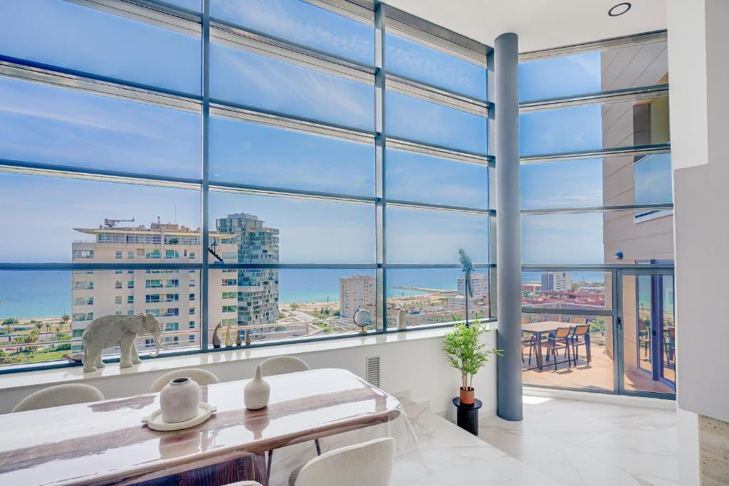a room with large windows and a table and chairs at Penthouse Duplex with TOP Views! in Barcelona