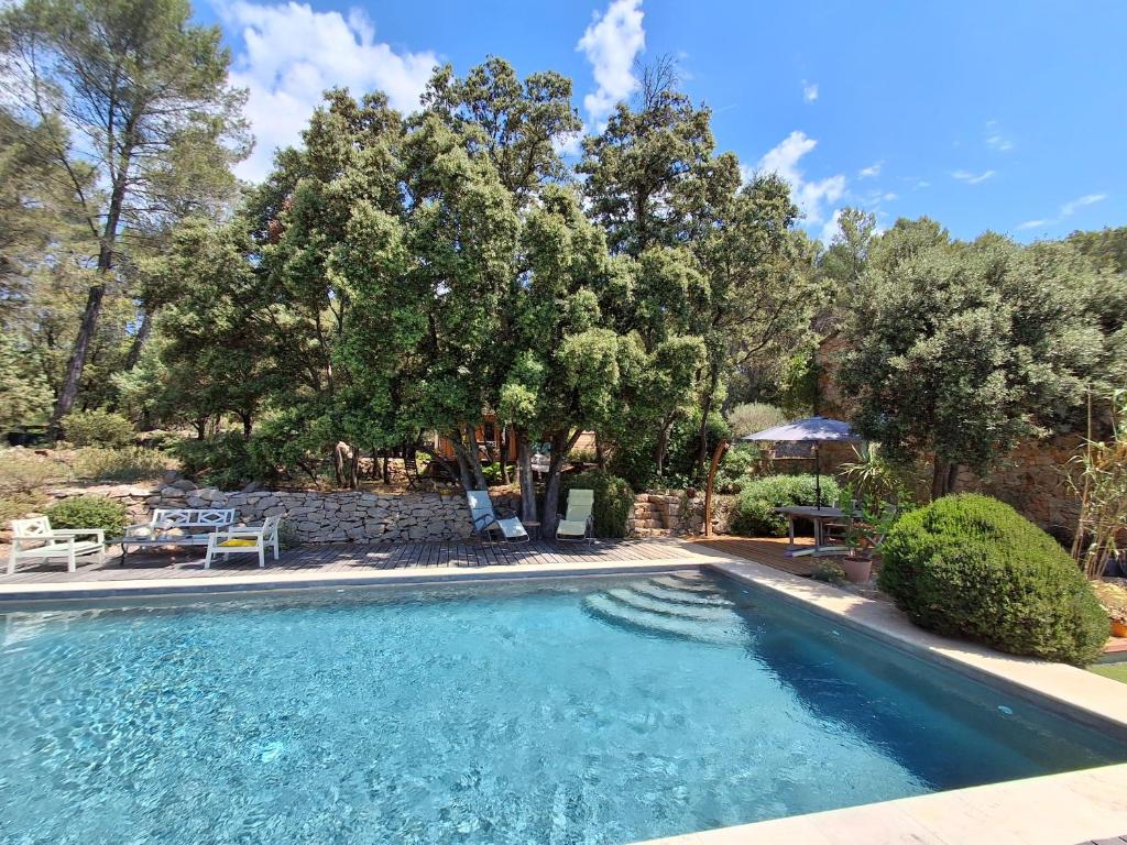 a swimming pool in a yard with trees at la bergerie des colles in Entrecasteaux