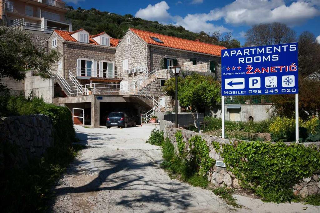 una señal frente a un edificio con una casa en Apartments Zanetić, en Zaton