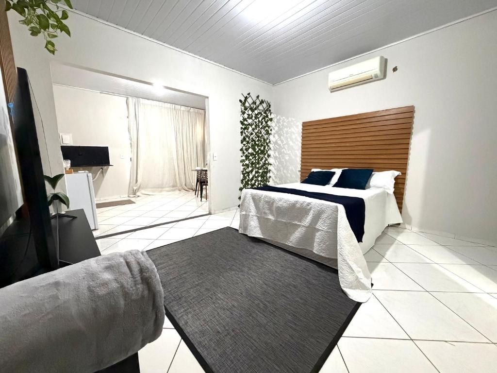 a bedroom with a bed and a television and a rug at Suíte premium Ar , WI-FI e TV SMART in Rondonópolis