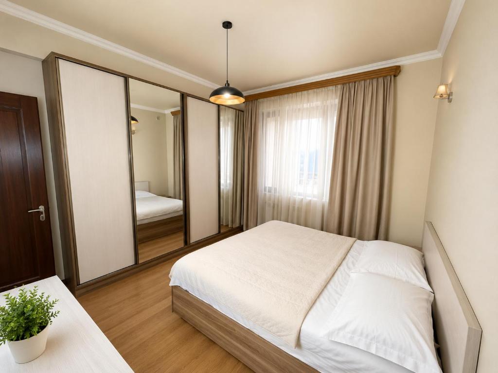 a bedroom with a bed and a large mirror at Republic Square Apartment in Yerevan