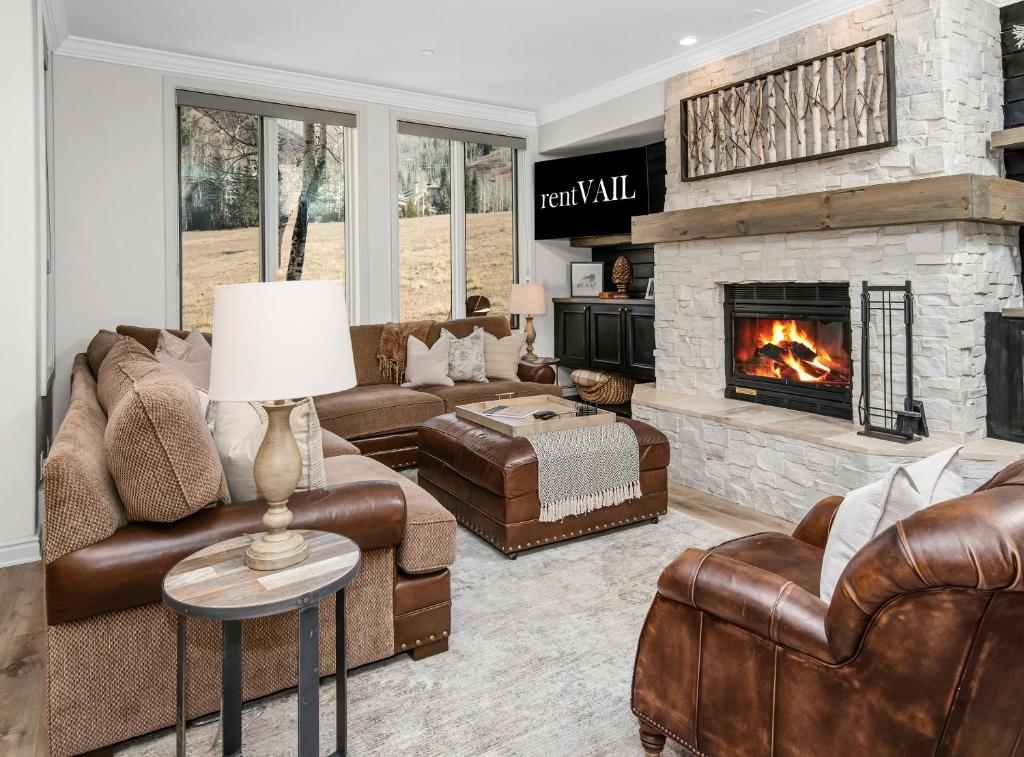 a living room with leather furniture and a fireplace at Highlands Slopeside in Beaver Creek
