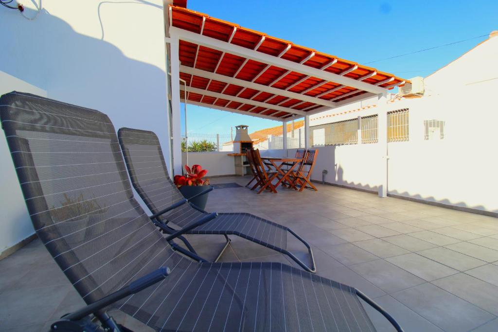 a chair sitting on a patio with a roof at Sentinela Place in Azinhal