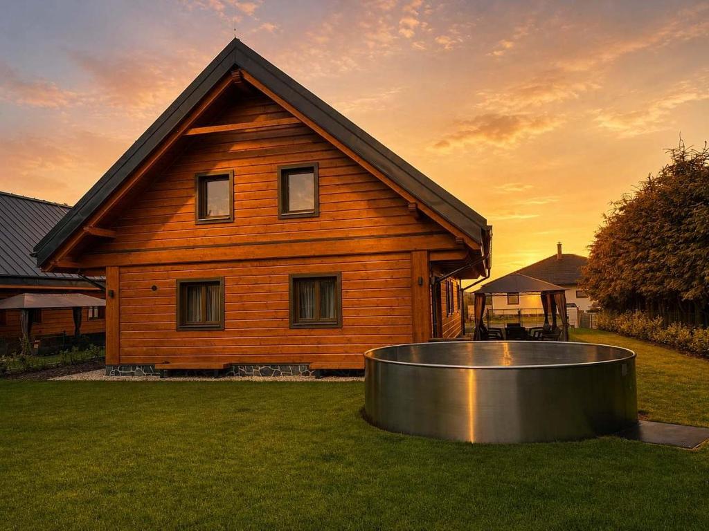 a wooden house with a ring in front of it at Chalupa Nicol in Vítějeves